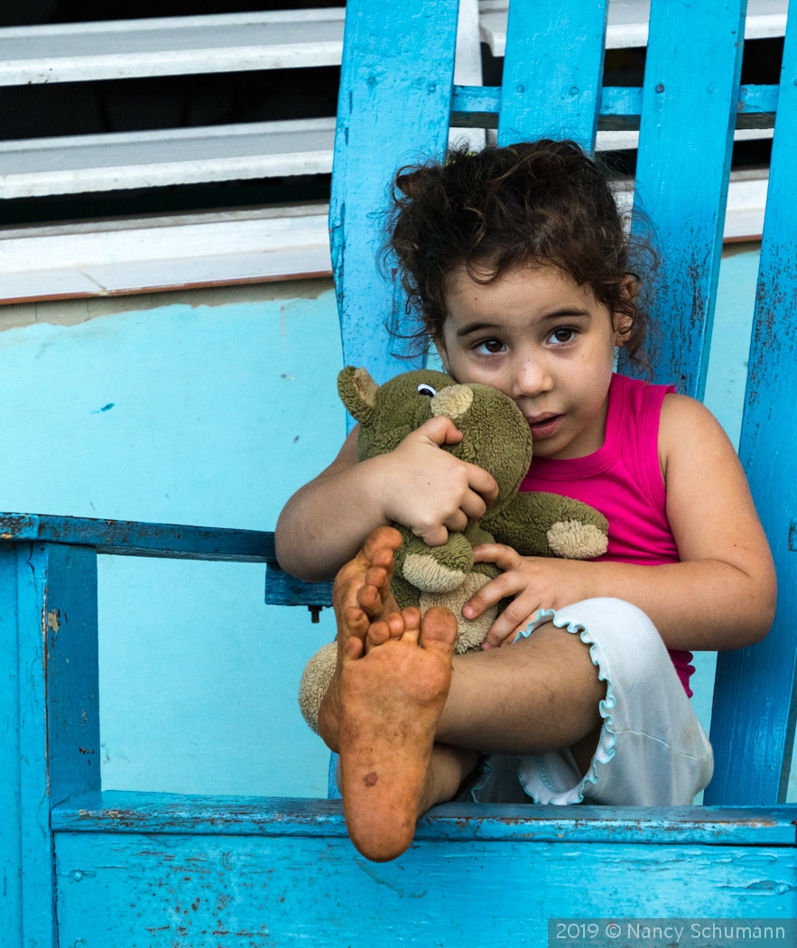 Cuban girl with toy by Nancy Schumann