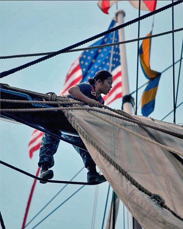 USS Constitution Sailor Aloft Bending On Sail by Lou Norton